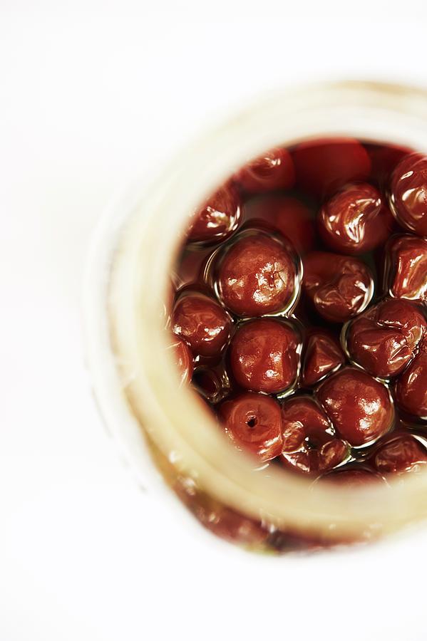 Overhead Of An Open Jar Of Cherries Preserved In Alcohol Photograph by Rannells, Greg