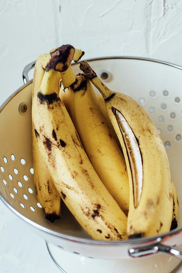 Overripe Bananas In A Colander Photograph by Kate Prihodko