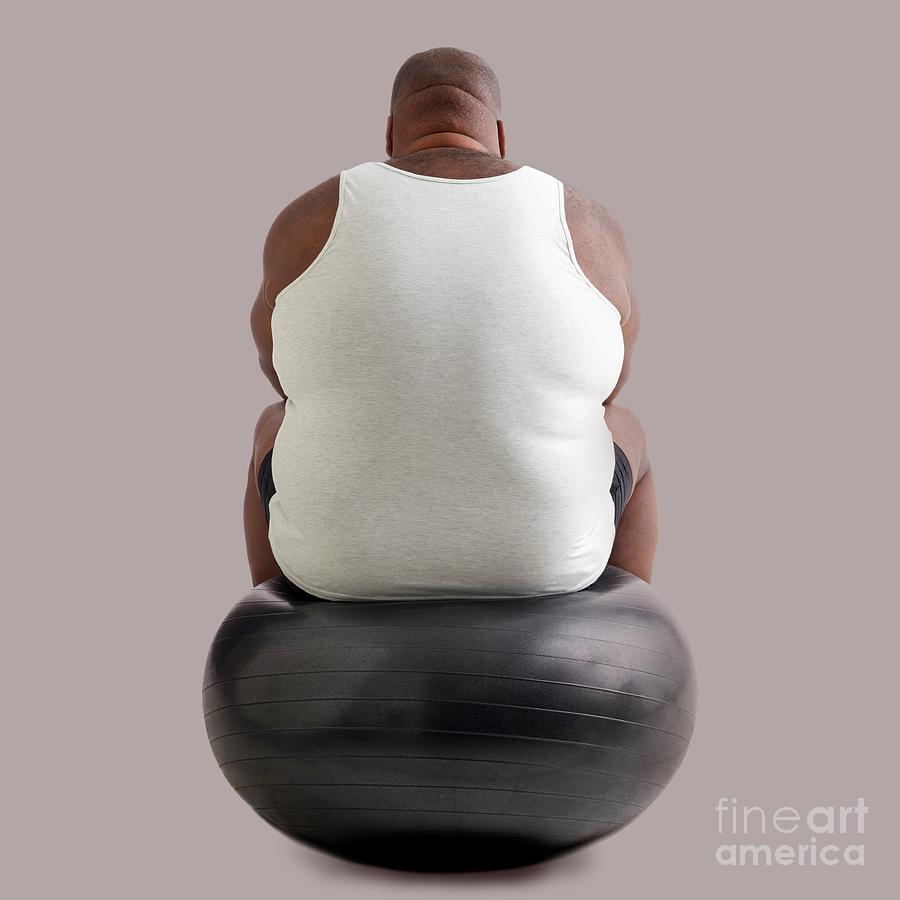 Overweight Man Sitting On An Exercise Ball Photograph by Science Photo Library