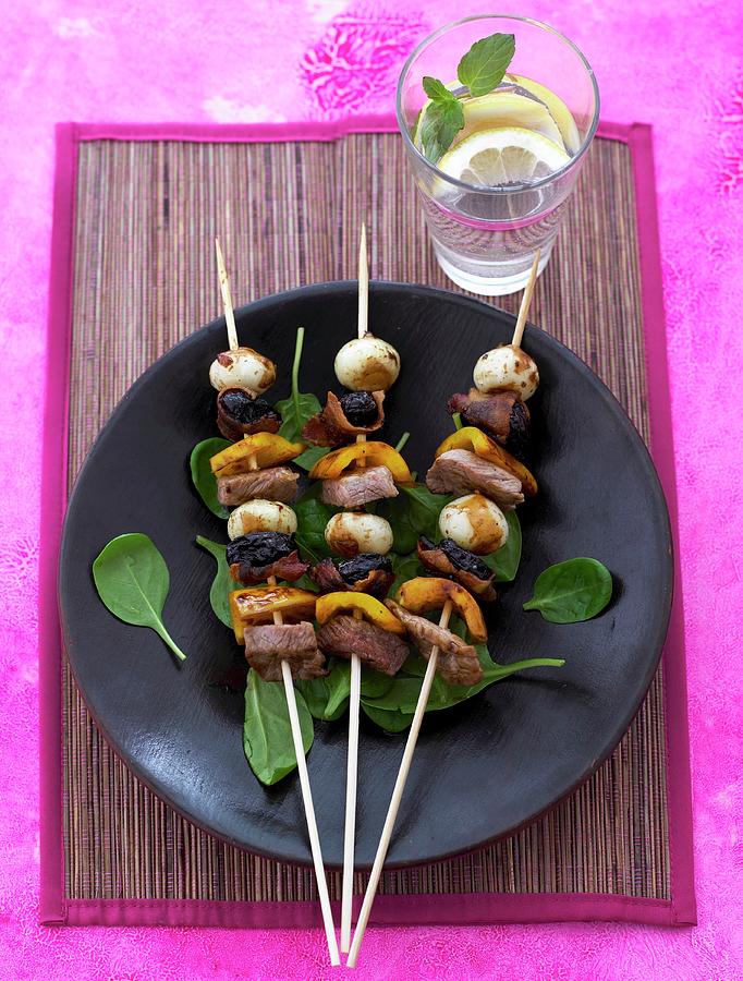 Ox Meat Skewers With Plums And Mini Mozzarella On A Bed Of Basil Leaves Photograph by Mikkel Adsbl