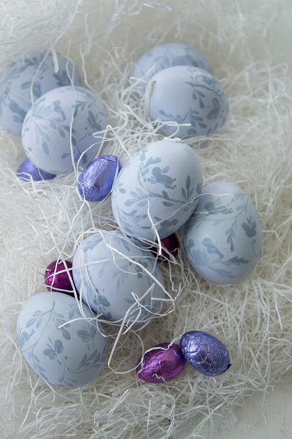 Painted Easter Eggs And Chocolate Eggs Amongst Shredded Paper Photograph by Martina Schindler