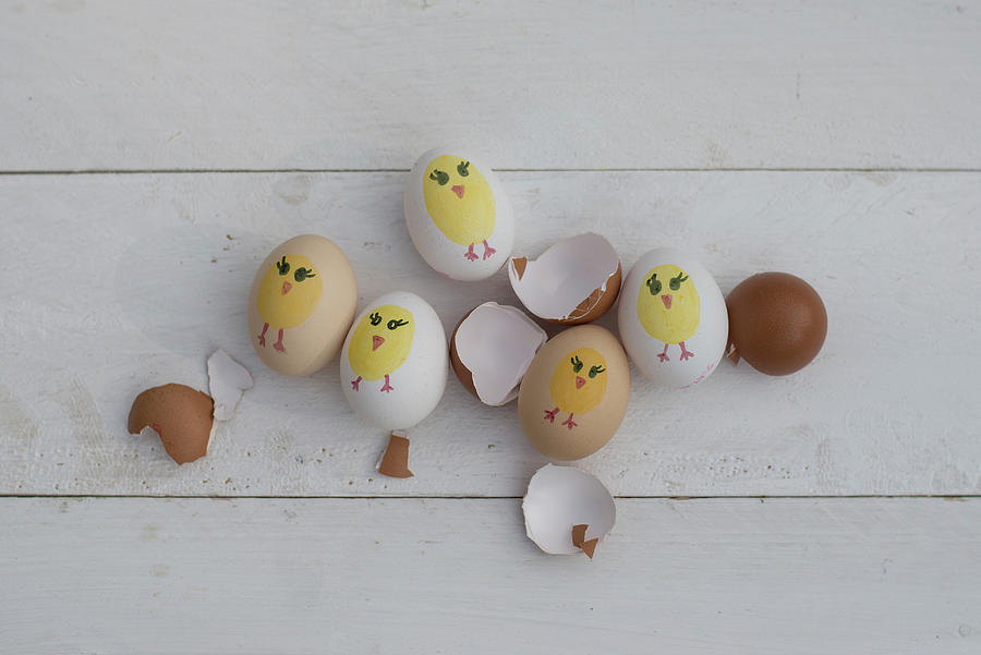 Painted Easter Eggs And Egg Shells On White Wooden Surface Photograph by Patsy&christian