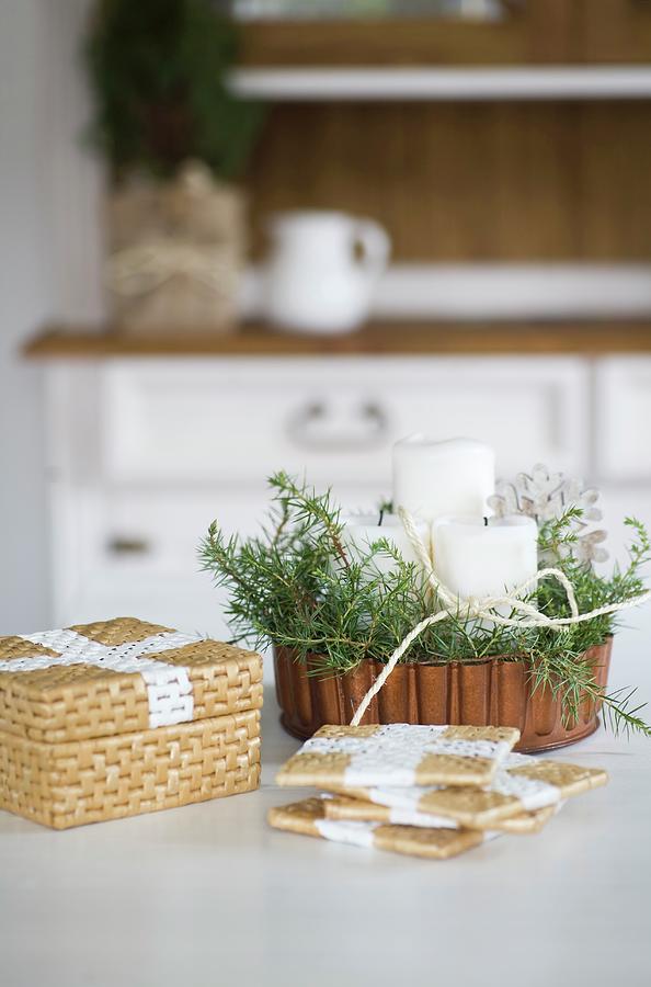 Painted Seagrass Coasters In Front Of Christmas Arrangement In Copper Cake Tin Photograph by Alicja Koll