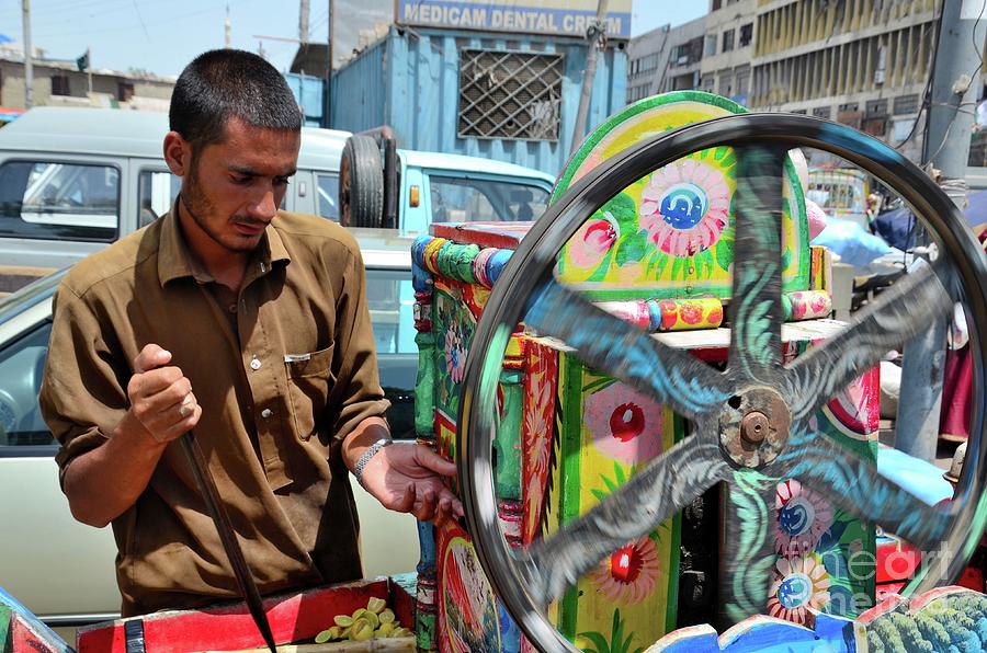 Pakistani man tends colorful sugar cane juice machine Karachi Pakistan Photograph by Imran Ahmed