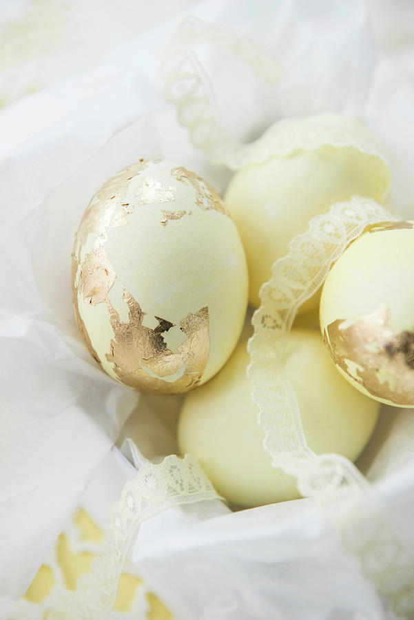 Pale Yellow Easter Eggs With Gold Leaf And Lace Ribbons Photograph by Ruud Pos