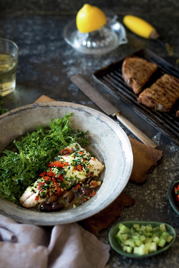Pan Fried Hake With Tomatoes, Olives And Garlic Served With Griddled Sourdough And Salad Photograph by Joan Ransley