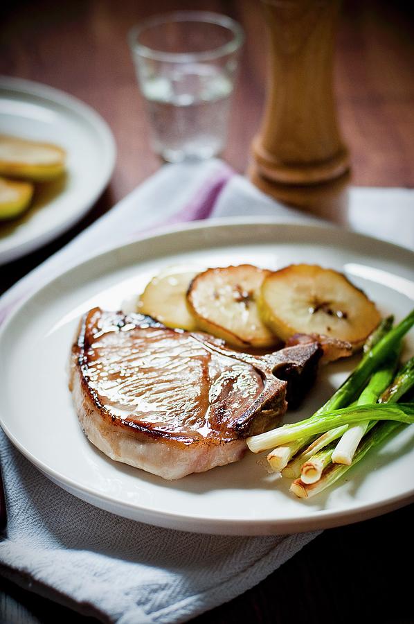 Pan Fried Pork Chop With Caramelised Apple Slices And Fried Spring Onions Photograph by Tomasz Jakusz