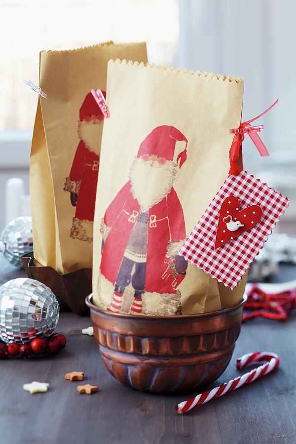 Paper Gift Bags With Father Christmas Motifs In Jelly Moulds Photograph by Franziska Taube