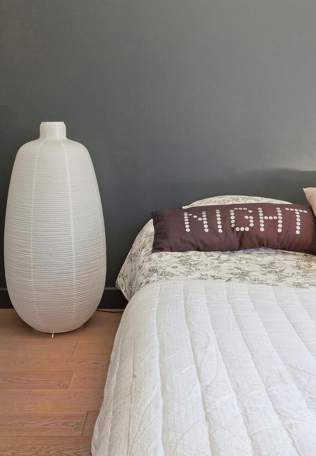 Paper Lantern On Floor Next To Bed And Pillow With Motto night On Bed Photograph by Anne-catherine Scoffoni