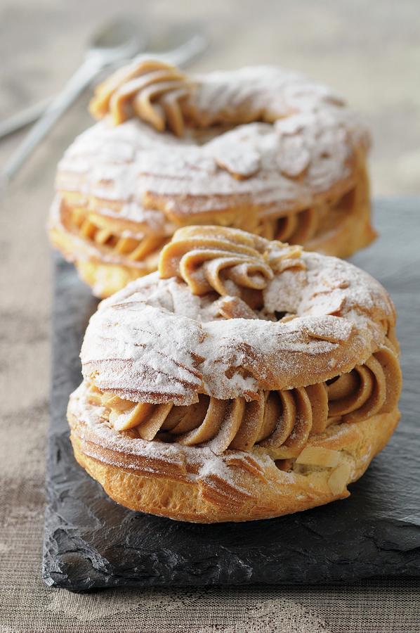 Paris Brest choux Pastries With Hazelnut Cream, Slivered Almonds And Icing Sugar, France Photograph by Jean-christophe Riou
