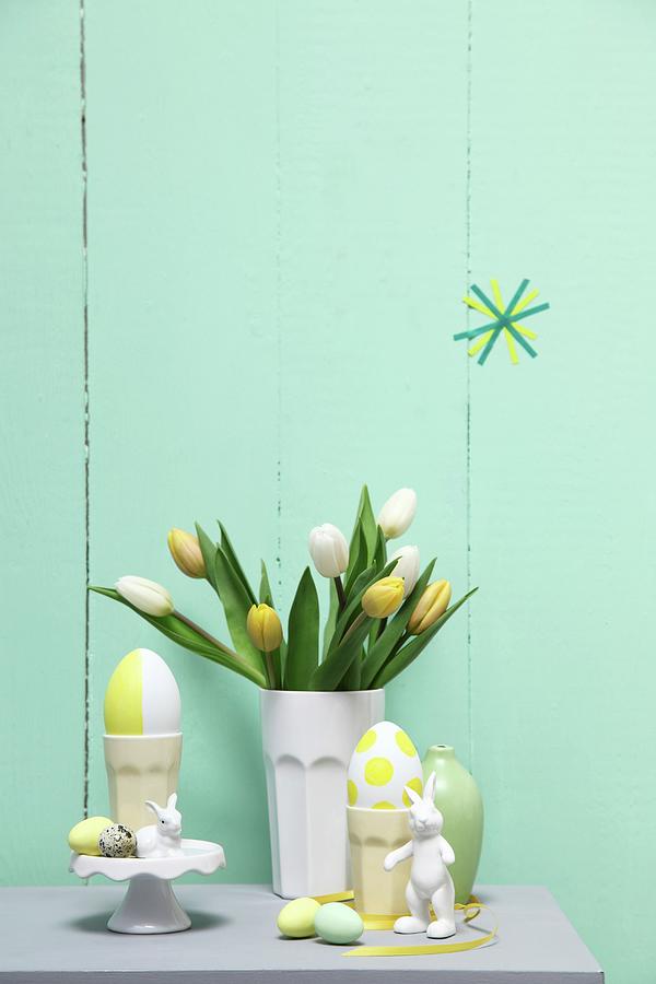 Pastel Easter Arrangement; Tulips In Ceramic Beaker, Eggs And Rabbit Ornaments Photograph by Thordis Rggeberg