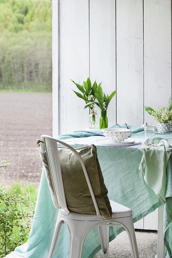Pastel Tablecloth, Vases Of Lily Of The Valley And Place Settings On Table Next To Chair With Cushion Photograph by Annette Nordstrom