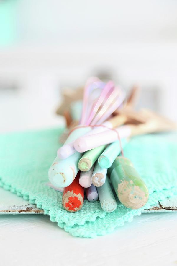Pastel Wooden Spoons Tied With Rubber Band On Lacy Turquoise Doily Photograph by Syl Loves