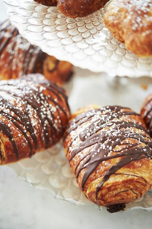Pastries Drizzled With Chocolate And Dusted With Powdered Sugar On A