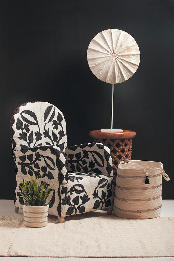 Patterned Armchair, Fabric Basket And Side Table In Front Of Black Wall Photograph by Great Stock!