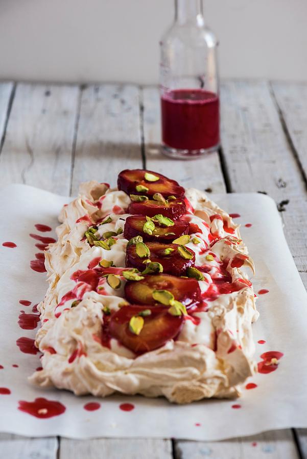 Pavlova With Plums And Pistachios Photograph by Hein Van Tonder