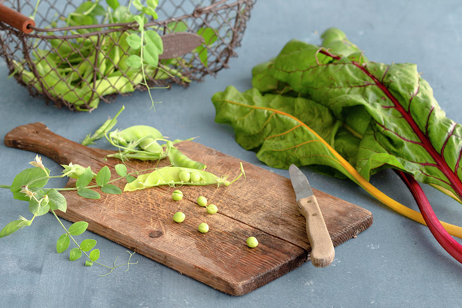 Pea Pods On A Wooden Board Next To Colourful Chard Stems Photograph by Tina Engel
