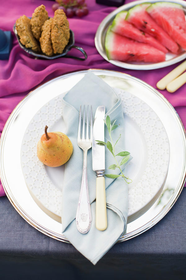 Pear, Cutlery And Folded Napkin On Plate Photograph by Alicja Koll