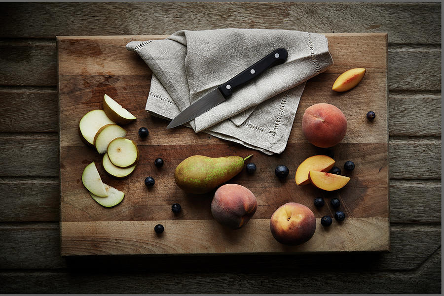 Pears Sliced And Whole With Blueberries And Peaches On A Wooden Chopping Board Photograph by Cliqq Photography