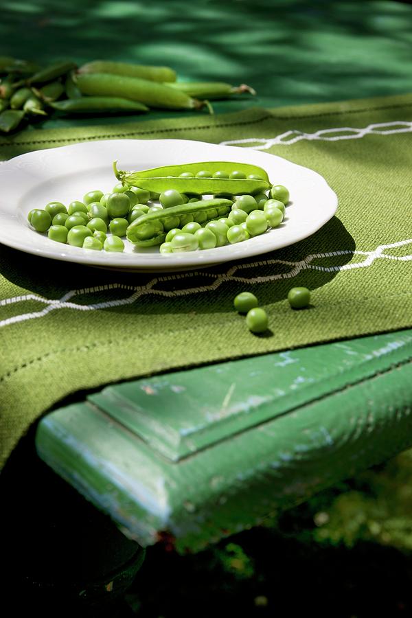 Peas organic, Partly Podded, With Whole Pods On A Plate And On A Table Photograph by Sabine Lscher
