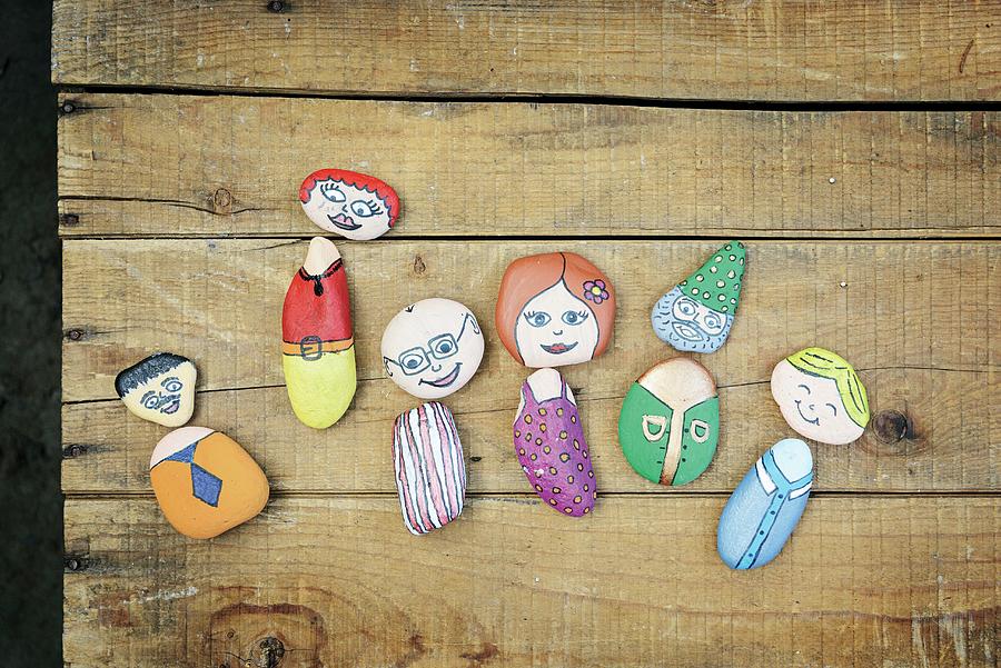 Pebbles Painted As Whimsical Characters On Rustic Wooden Surface Photograph by Patsy&christian