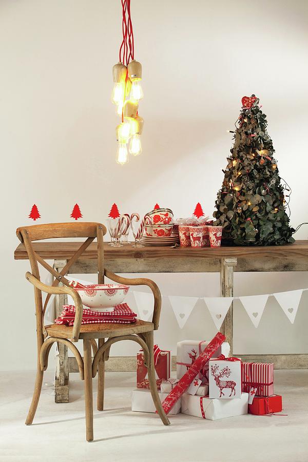 Pendant Lamp Above Festively Decorated Rustic Wooden Ceiling, Vintage Chair And Christmas Presents Wrapped In Red And White Paper Photograph by Great Stock!