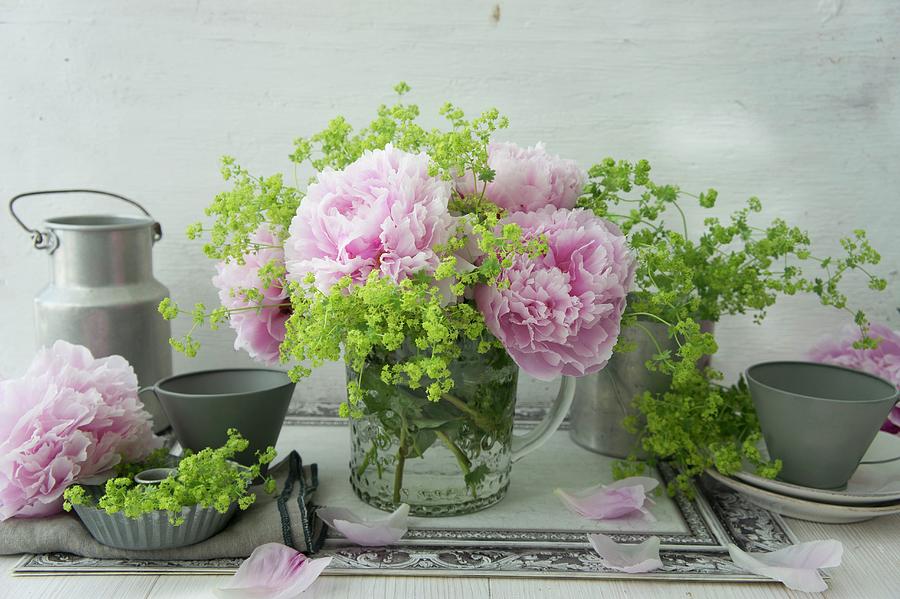 Peonies And Ladys Mantle In Glass Jug And Tin Utensils Photograph by Martina Schindler