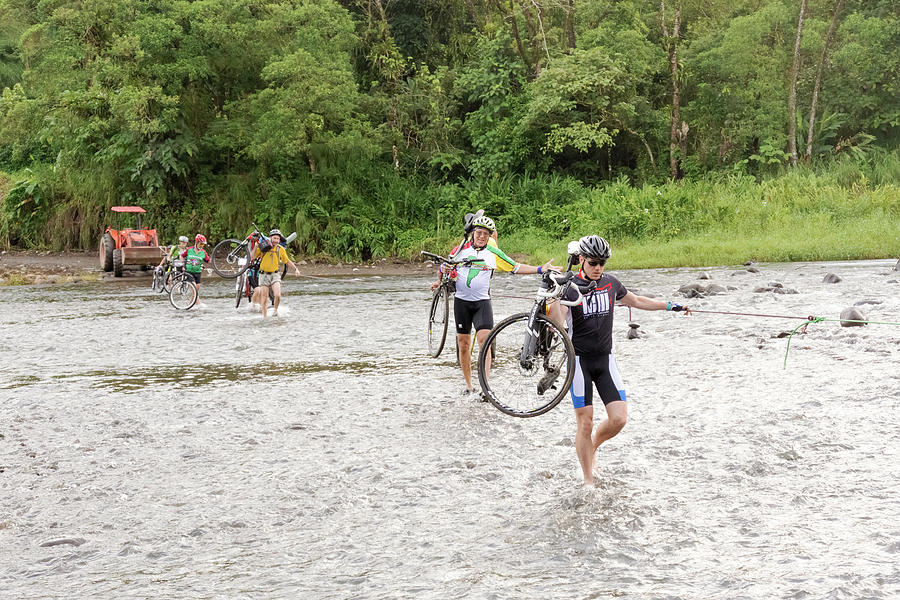 People with bicycles are crossing Rio Cano Negro in Costa Rica Photograph by Marek Poplawski