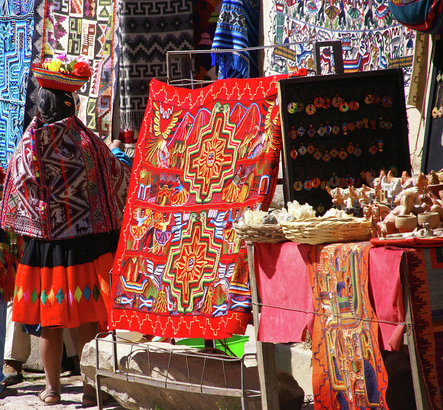 Peruvian Indian woman looking at colorful textiles Photograph by Steve Estvanik