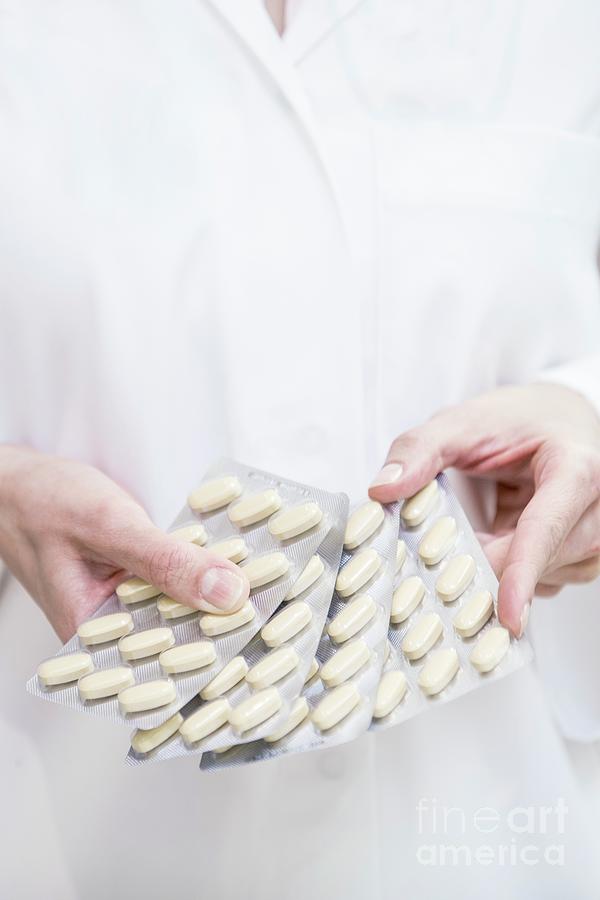 Pharmacist Holding Pills In Blister Packs Photograph by Science Photo Library