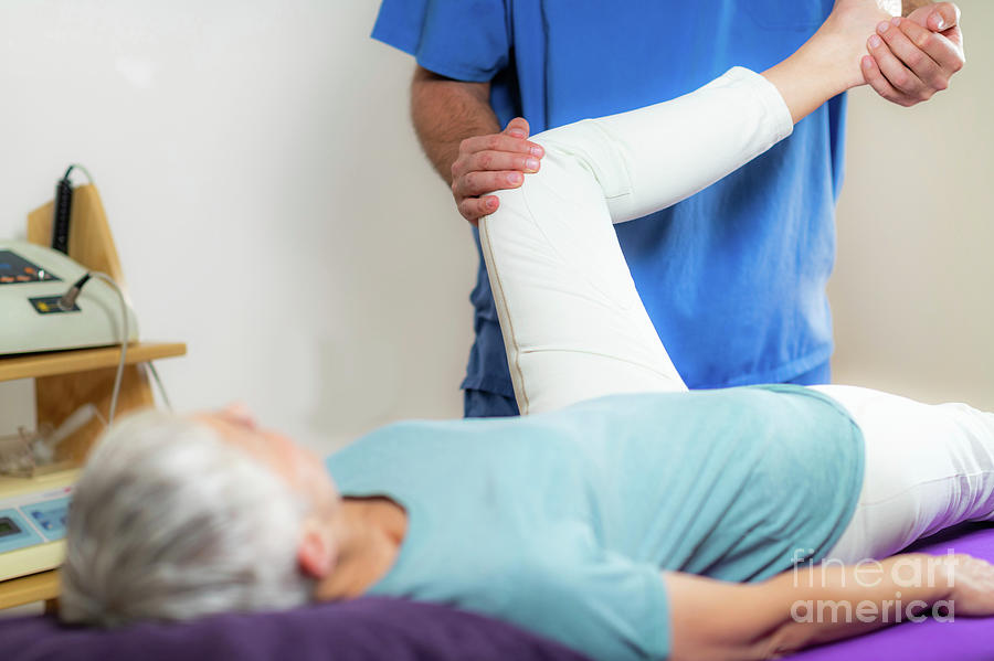 Physical Therapist Examining Patients Leg Photograph by Microgen Images/science Photo Library
