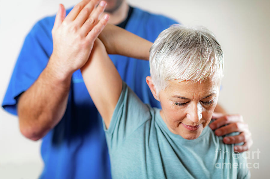Physical Therapist Examining Patients Shoulder Photograph by Microgen Images/science Photo Library
