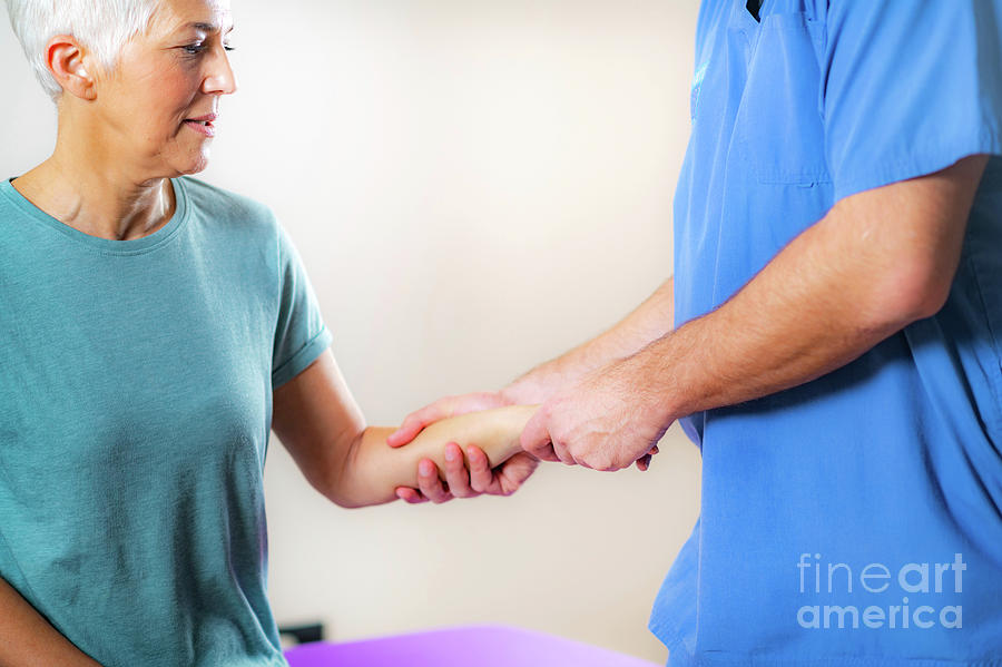 Physical Therapist Examining Patients Wrist Photograph by Microgen Images/science Photo Library