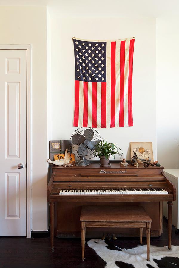 Piano And Piano Bench Below Flag Of The United States On Wall Photograph by Julia Cawley