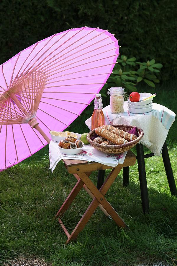 Picnic Of Bread Rolls And Lemonade Under Oriental Paper Parasol In Garden Photograph by Regina Hippel