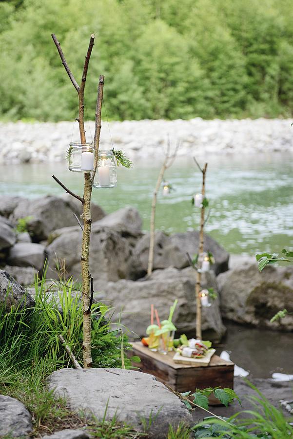 Picnic On Wooden Crate On River Bank With Candle Lanterns Hung From Branches Photograph by Patsy&christian