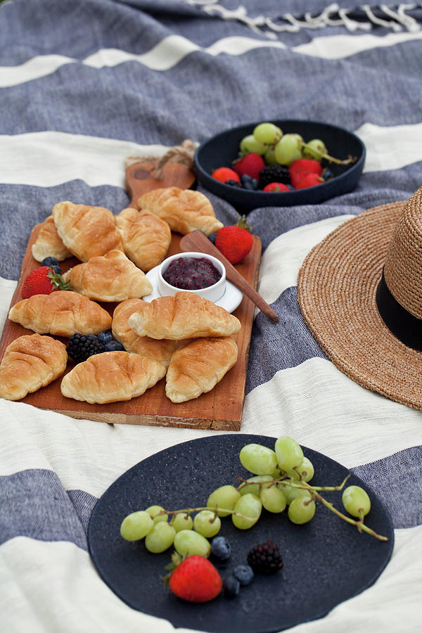 Picnic With Berries, Grapes, Croissants And Raspberry Jam On A Blue And White Striped Blanket Photograph by Ryla Campbell