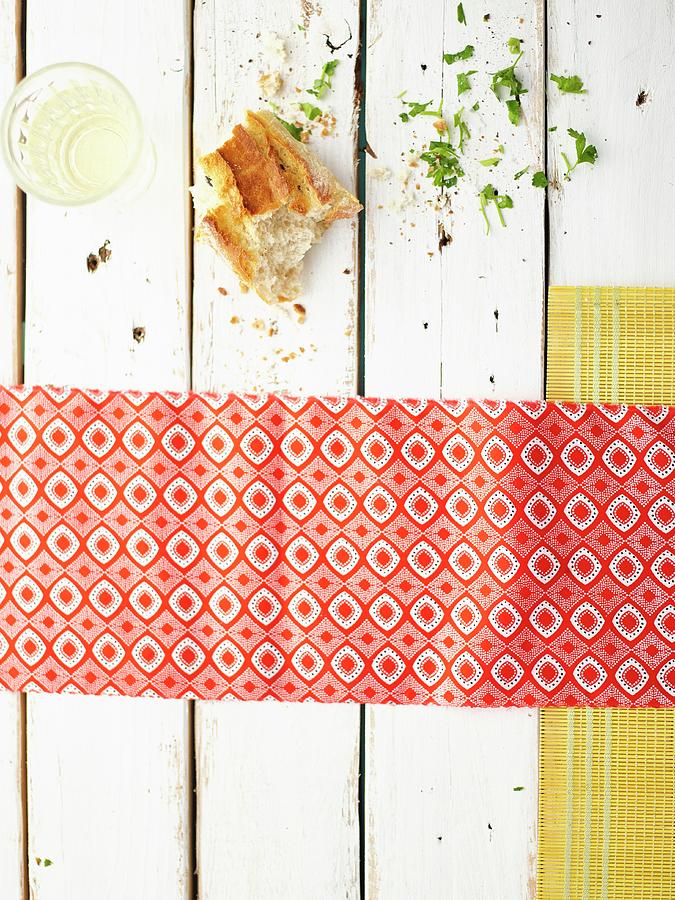 Pieces Of Bread And White Wine On A White Wooden Table With A Patterned Napkin Photograph by Great Stock!
