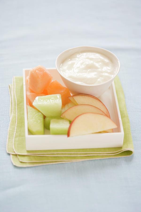Pieces Of Melon And Apple Wedges With A Bowl Of Yoghurt Photograph by Colin Cooke