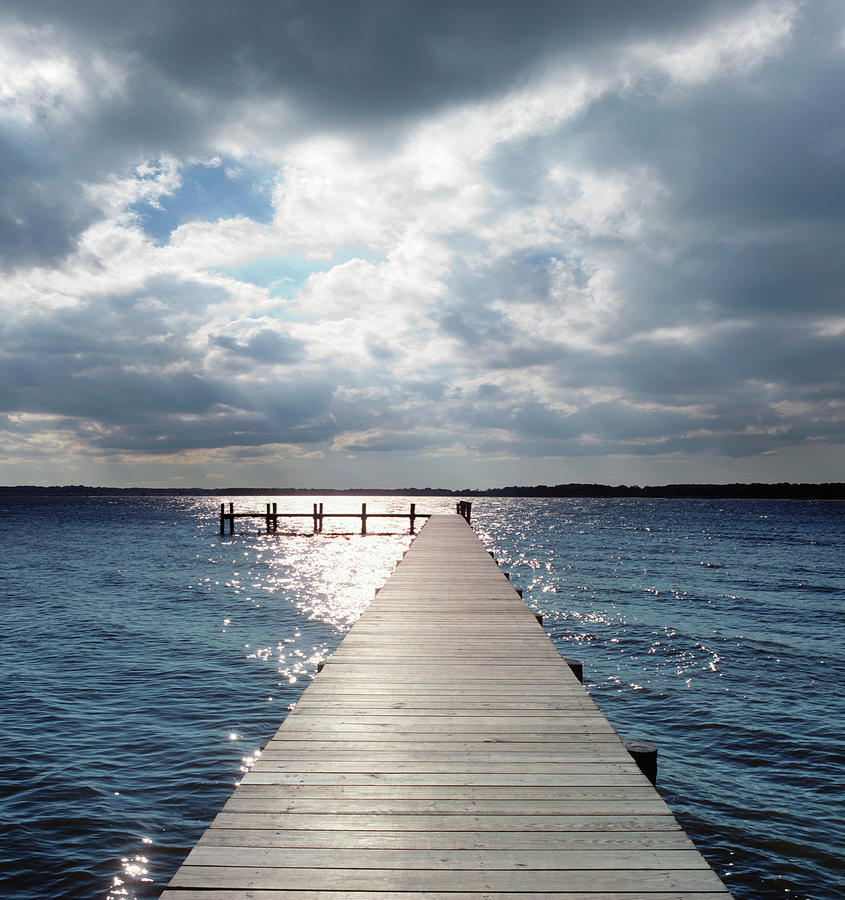 Pier Extending Into River Under Partly by Greg Pease