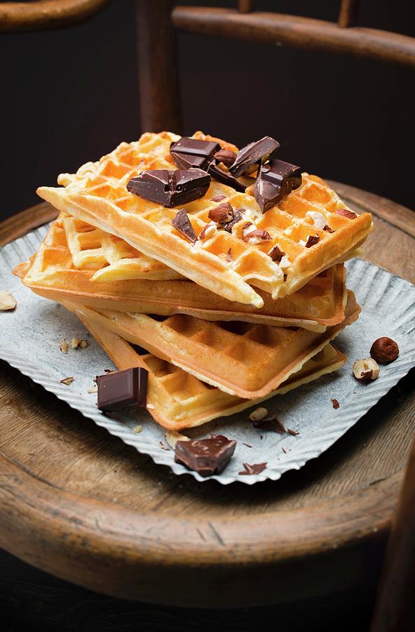 Pile Of Brussels Waffles, Squares Of Dark Chocolate And Hazelnuts Photograph by Hallet