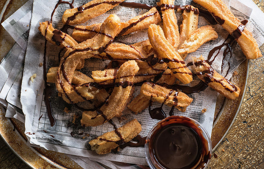 Pile Of Churros On Spanish Language Newspaper Drizzled With Chocolate Sauce Photograph by Justin B. Paris