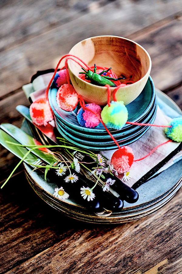Pile Of Dishes With Daisies And Garlands On A Wooden Table Outdoors Photograph by Amiel