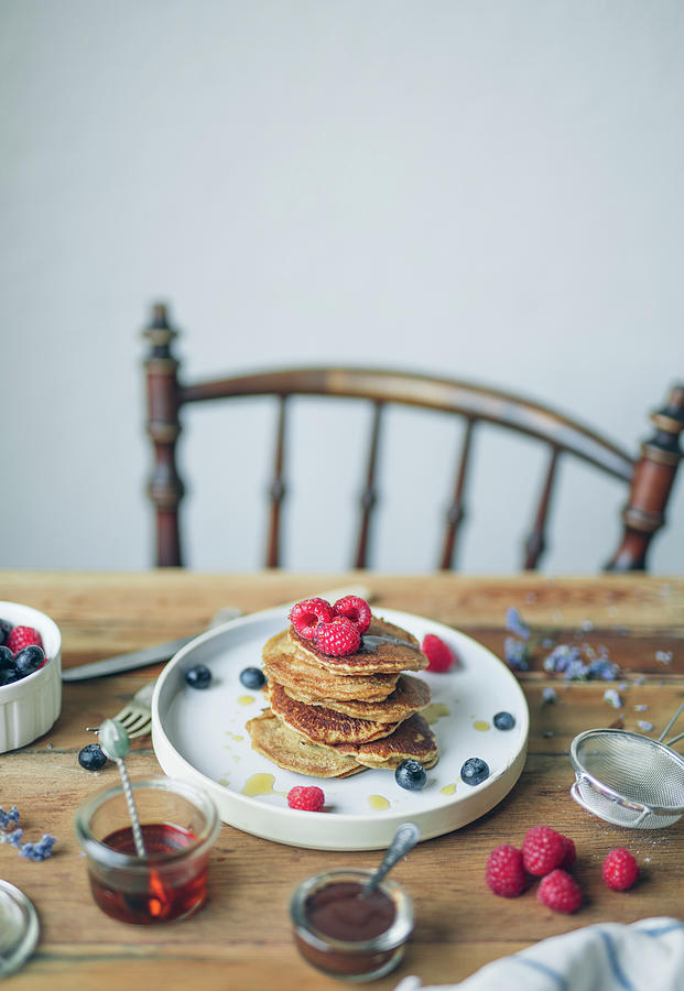 Pile Of Pancakes With Raspberries,blueberries And Maple Syrup Photograph by Velsberg