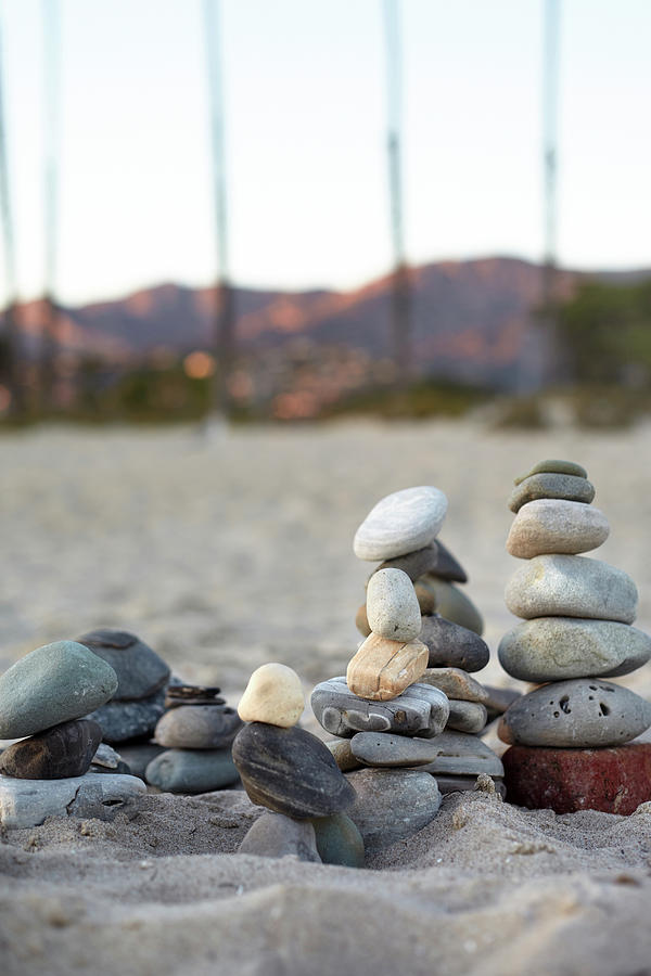 Piled Stones On The Beach In The Evening Light With A View Of The Santa Ynez Mountains In Santa Barbara, California, Usa. Photograph by Julia Franklin Briggs