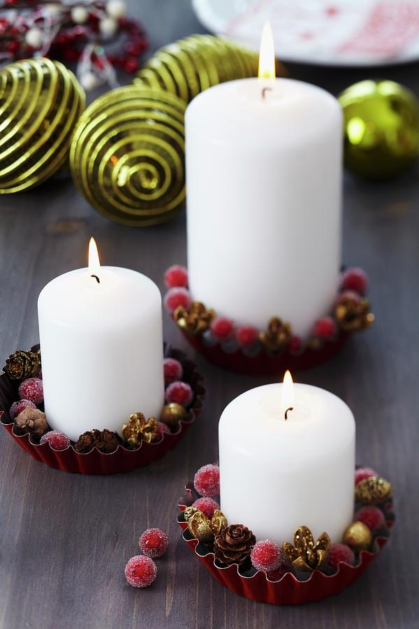 Pillar Candles And Christmas Decorations In Small Tart Tins Photograph by Franziska Taube