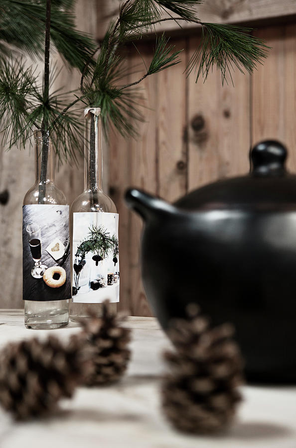 Pine Cones, Black Soup Tureen And Pie Sprigs In Old Bottles On Table Photograph by Lykke Foged & Morten Holtum