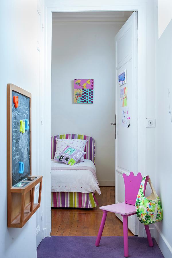 Pink Childs Chair Opposite Chalkboard In Small Anteroom With Open Door Showing View Of Bed With Striped Headboard And Valance Photograph by Christophe Madamour