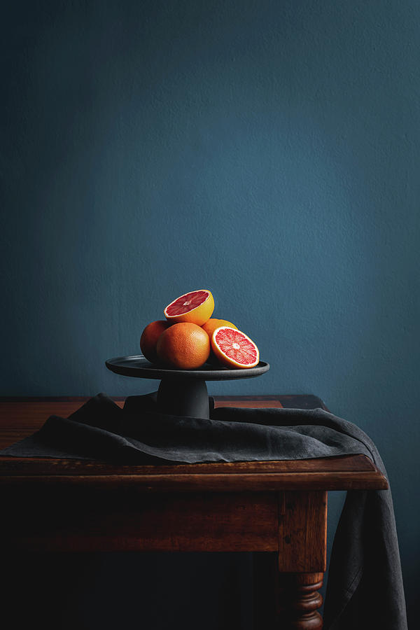 Pink Grapefruit, Whole And Halved On A Cake Stand Against A Dark Background Photograph by Great Stock!