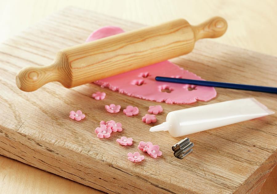 Pink Icing Rolled Out On A Board With Rolling Pin, Showing A Metal Flower Cutter And White Icing Tube Photograph by Stuart Macgregor